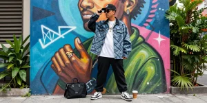 Stylish urban scene featuring a person in trendy 레플리카 clothing against colorful street art.