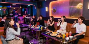 Experience the vibrant atmosphere of 인천쓰리노 with guests enjoying karaoke and drinks in a stylish lounge.